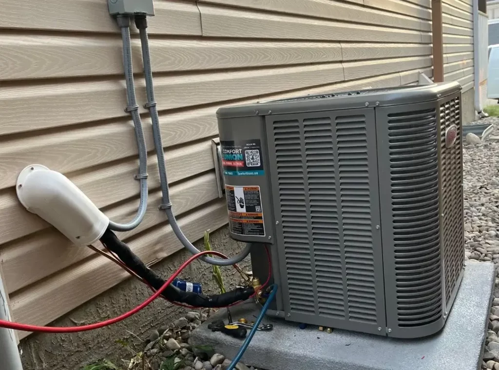Finished installation of Lennox air conditioner at Calgary residential home – side view with full wiring visible