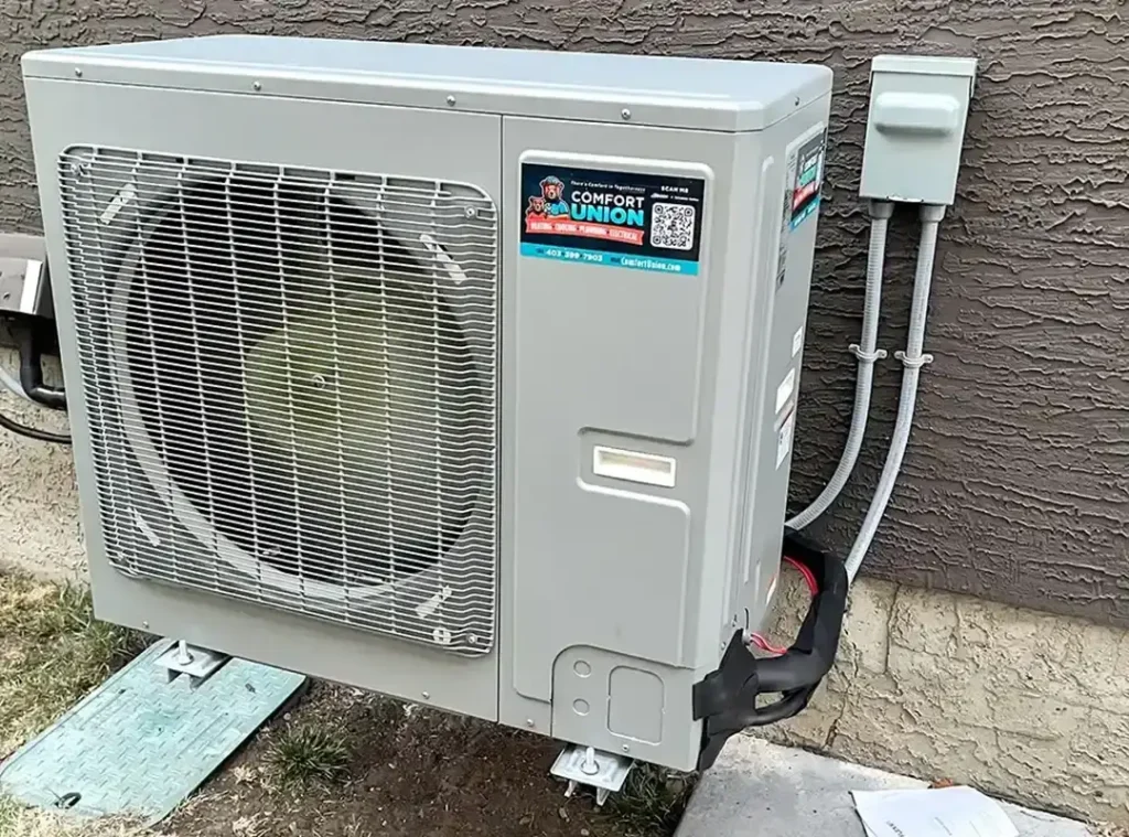 High-efficiency heat pump unit set up by Comfort Union next to a home exterior