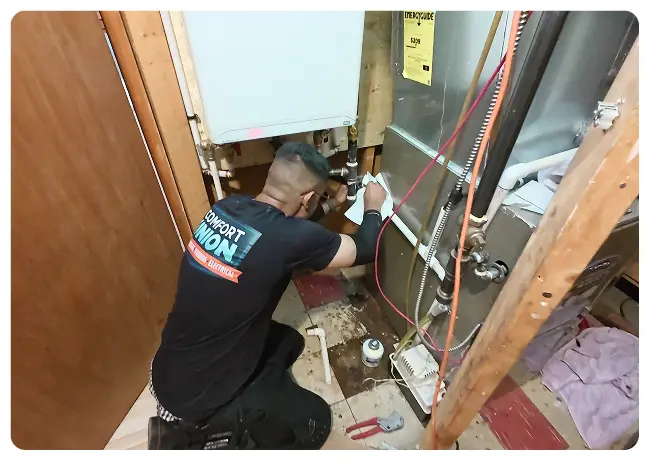 Comfort Union technician installing a tankless water heater in a Calgary home