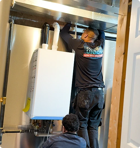 Technician from Comfort Union performing tankless water heater repair in Calgary